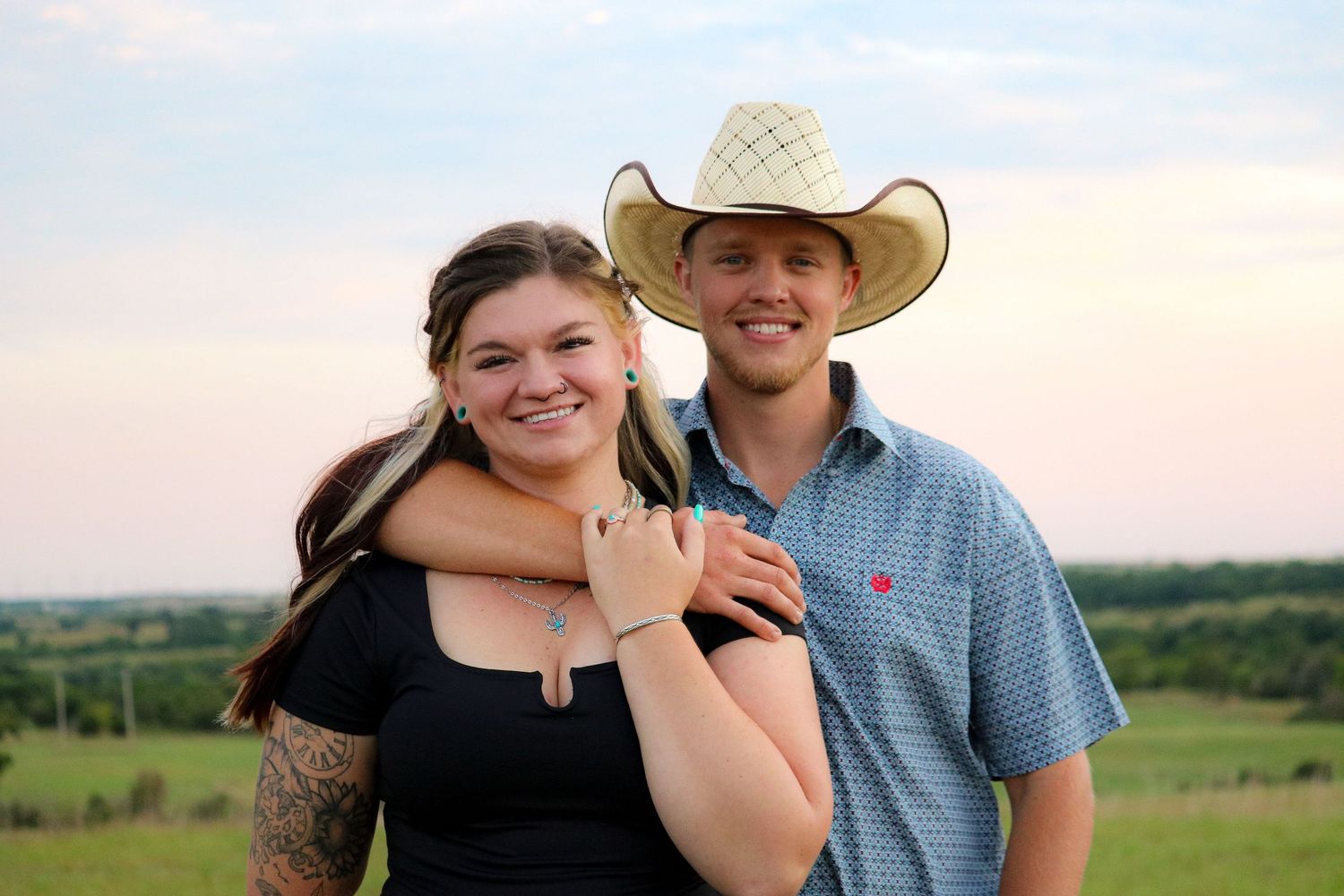 Romantic couple photo session against sunset sky in rural setting.