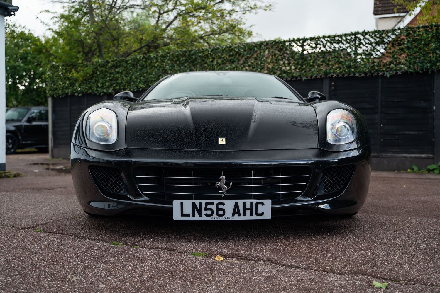 Front view of black Ferrari 599 GTB showing iconic headlights and grille design.