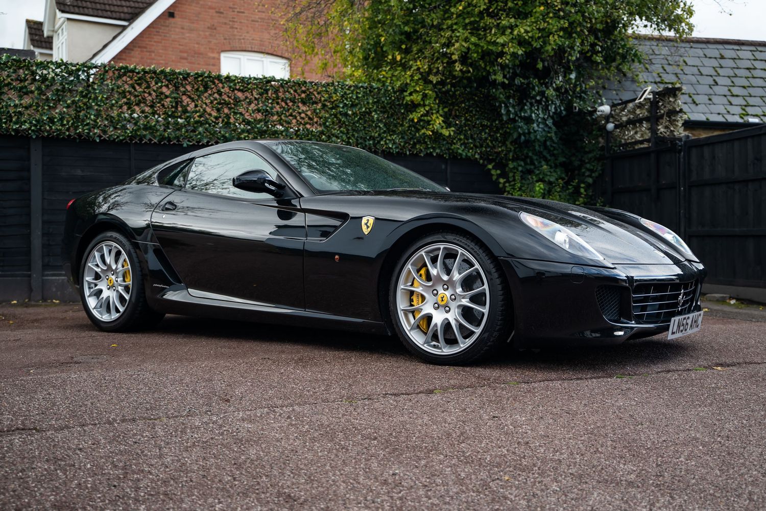 Side profile of black Ferrari 599 GTB displaying classic grand tourer proportions.