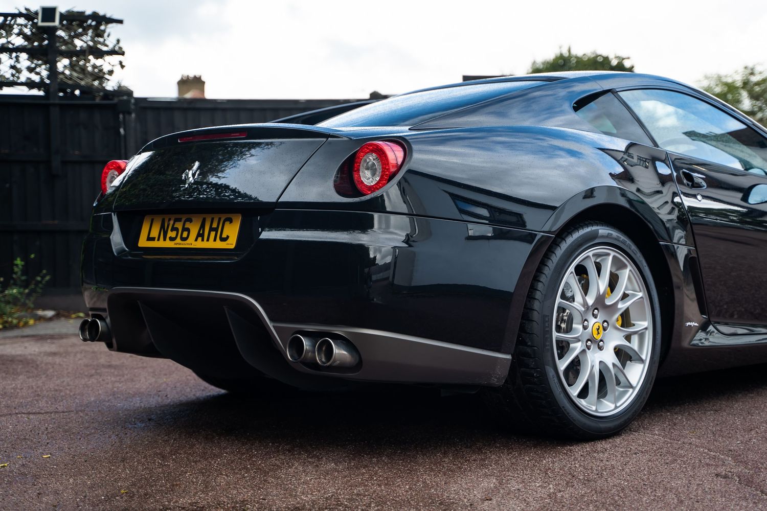 Sleek black Ferrari photographed from side angle showing elegant body lines and wheels.