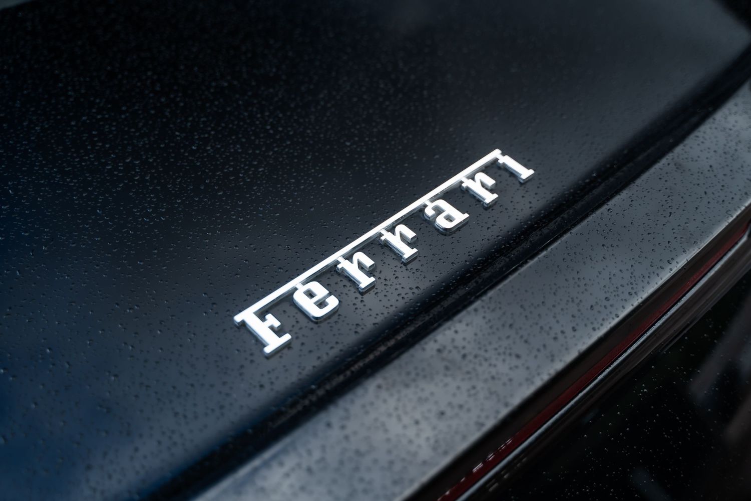 Ferrari FF badge and lettering detail on black paint finish.