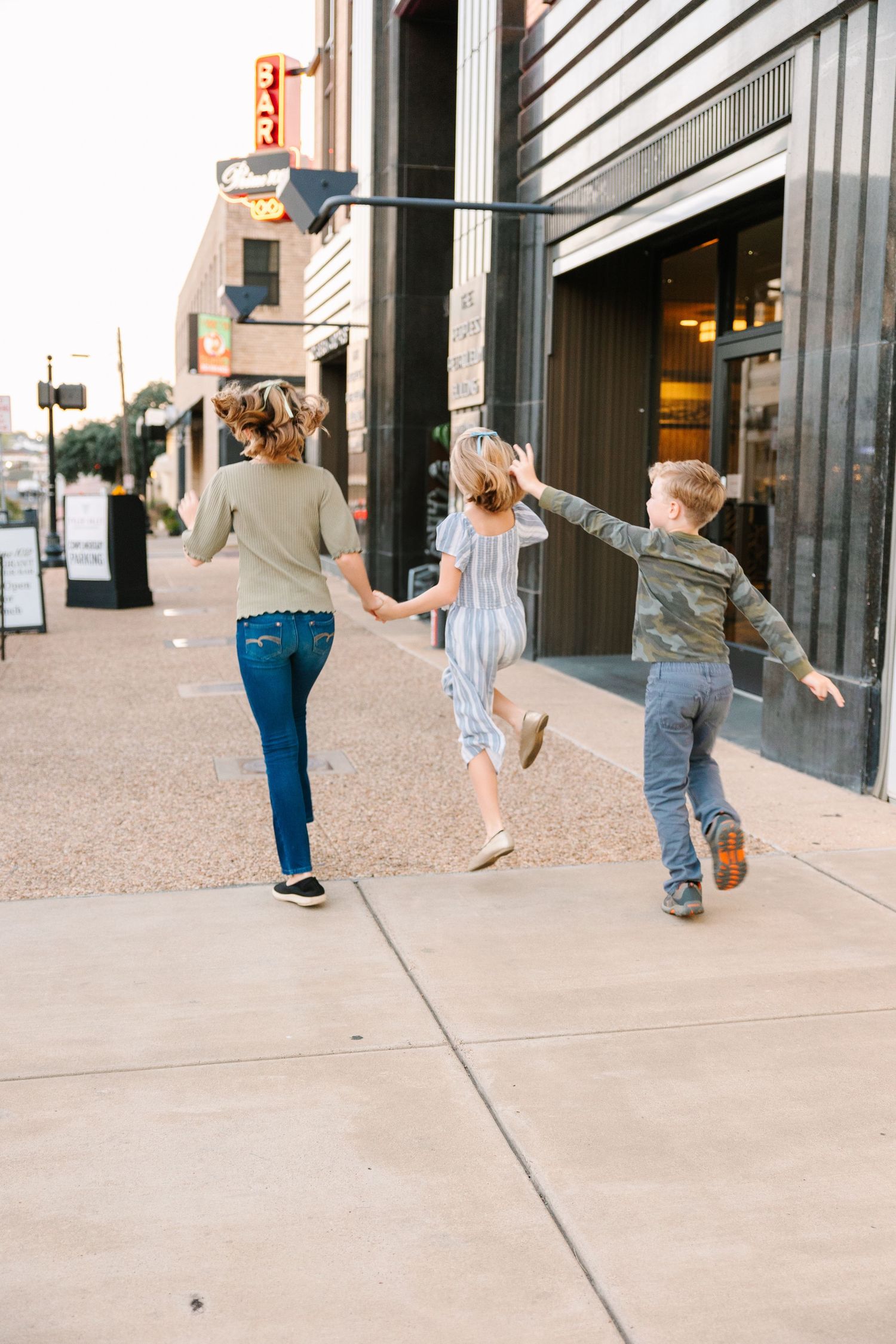 A sequence of images shows joyful dancing movements captured on a city sidewalk against a building exterior.