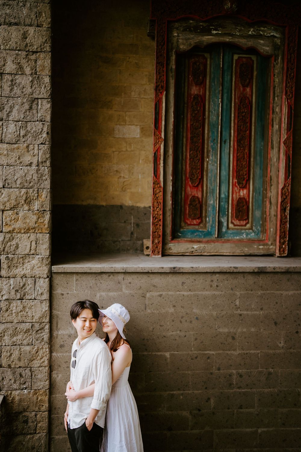 Romantic moment captured against weathered architectural details and antique doorway.