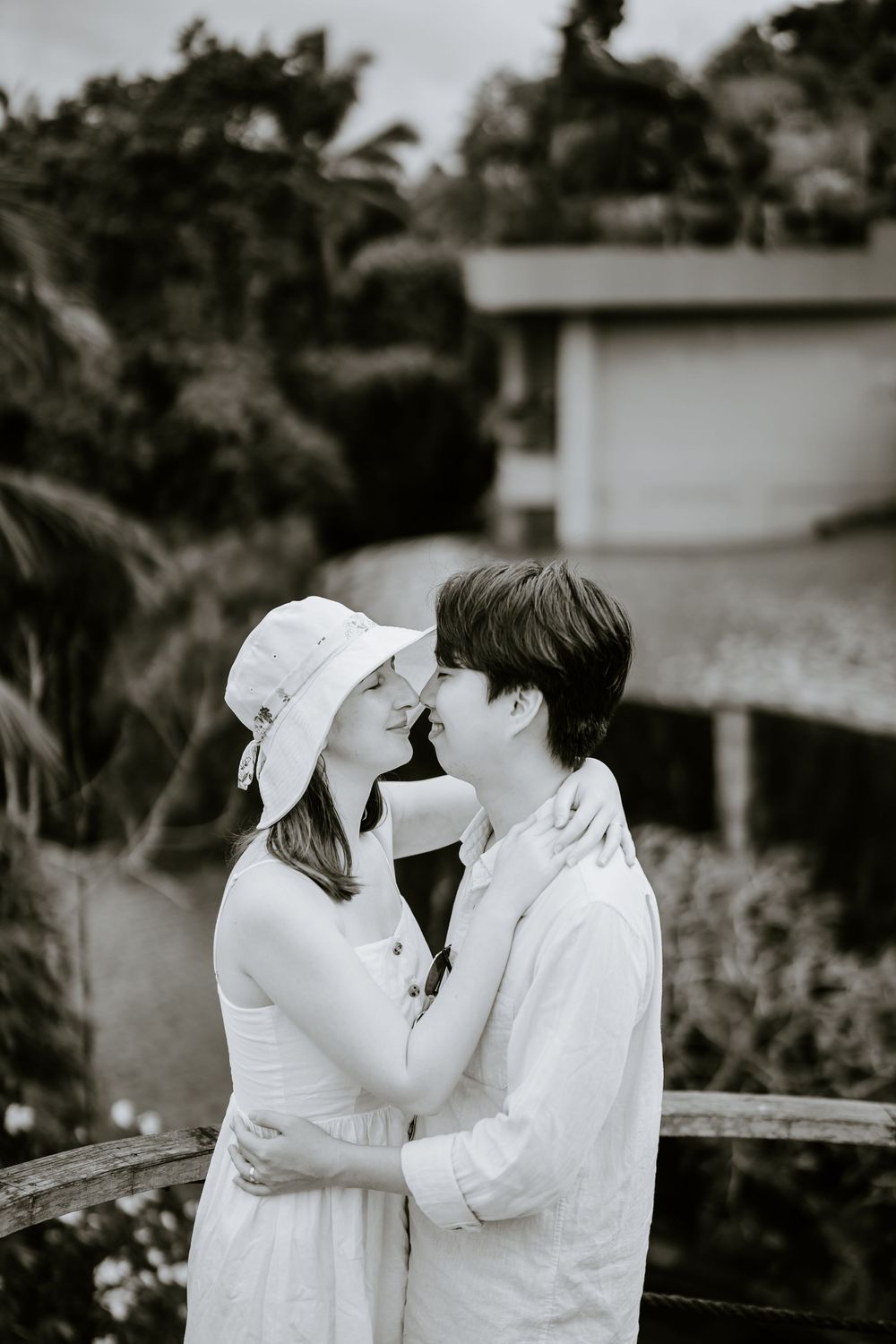 A romantic black and white photo series showing a couple in white outfits sharing tender moments together.