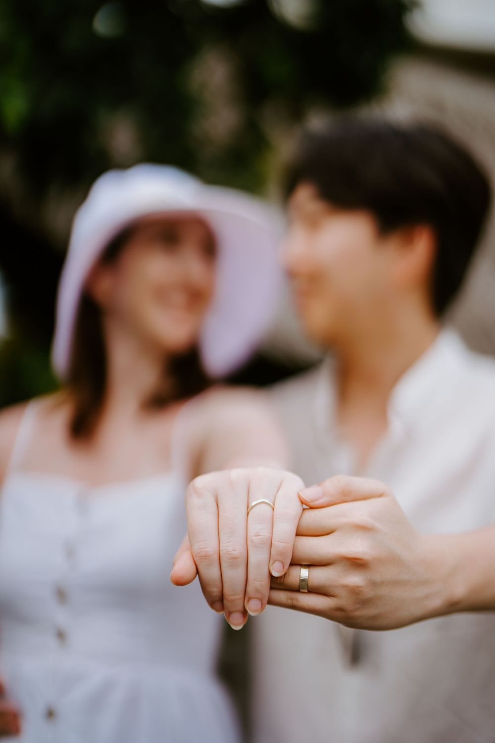 Close-up shots of hands with wedding rings against a soft blurred background.
