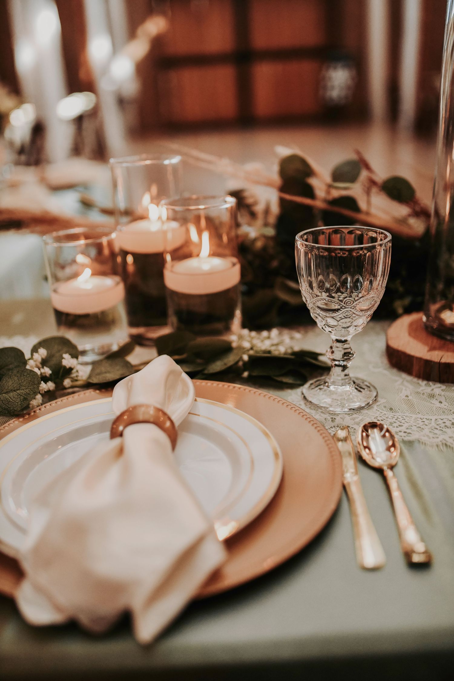 Elegant boho-inspired wedding décor with greenery runners and glowing candlelight
