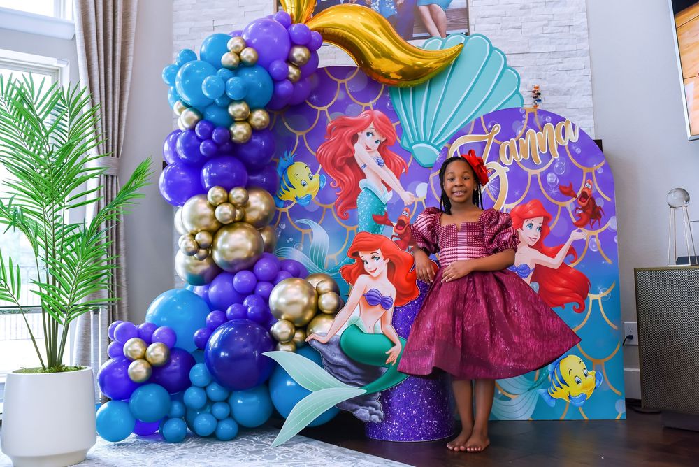Colorful balloon arch decorations with sea and mermaid theme elements create a magical party atmosphere.