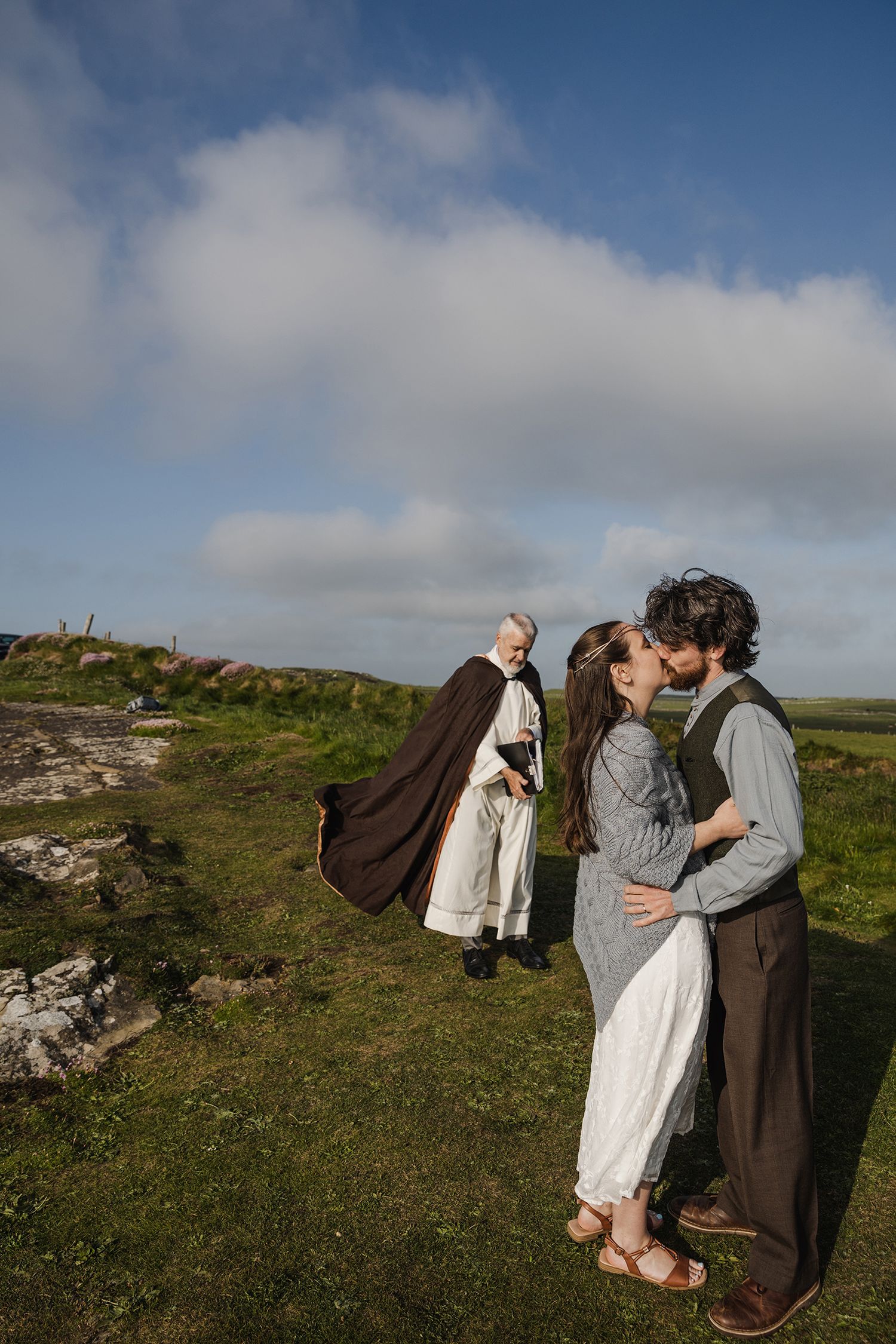 Couple performing traditional Celtic handfasting ritual during Cliffs of Moher sunset elopement
