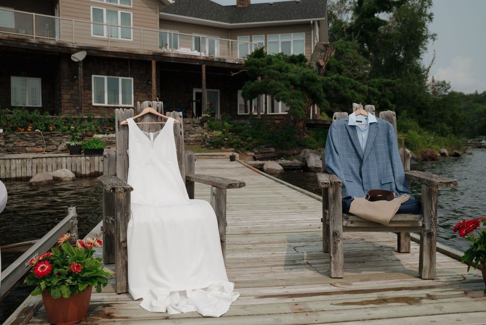 Lakeside wedding venue with wooden deck and residential buildings in the background.