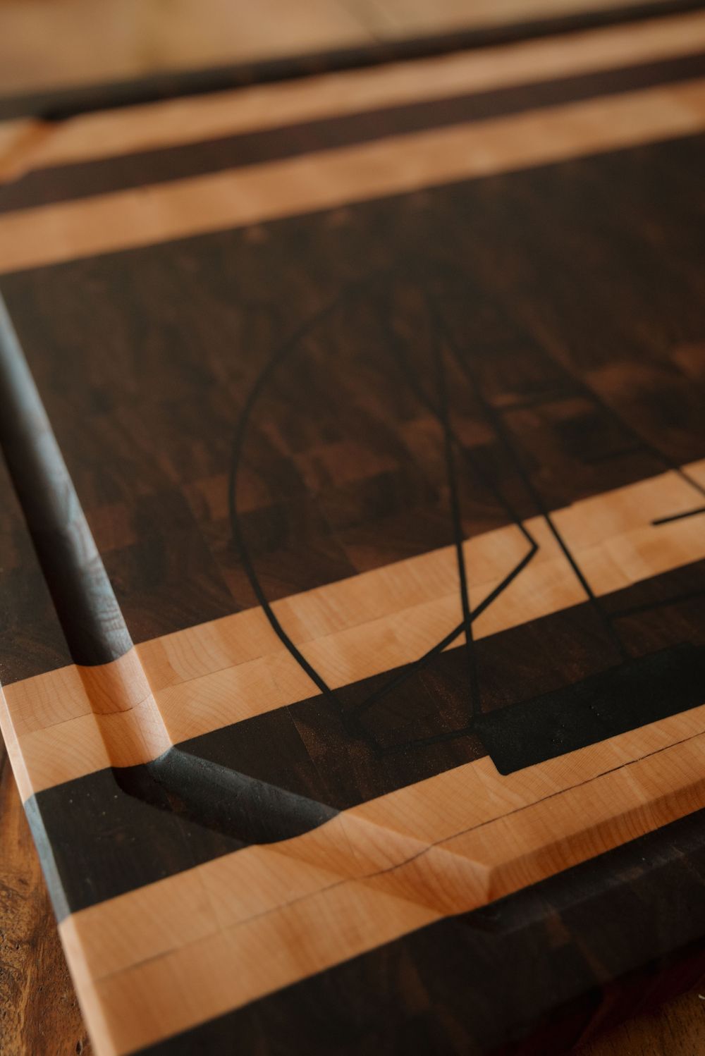 Dramatic shadows cast geometric patterns on a wooden surface.