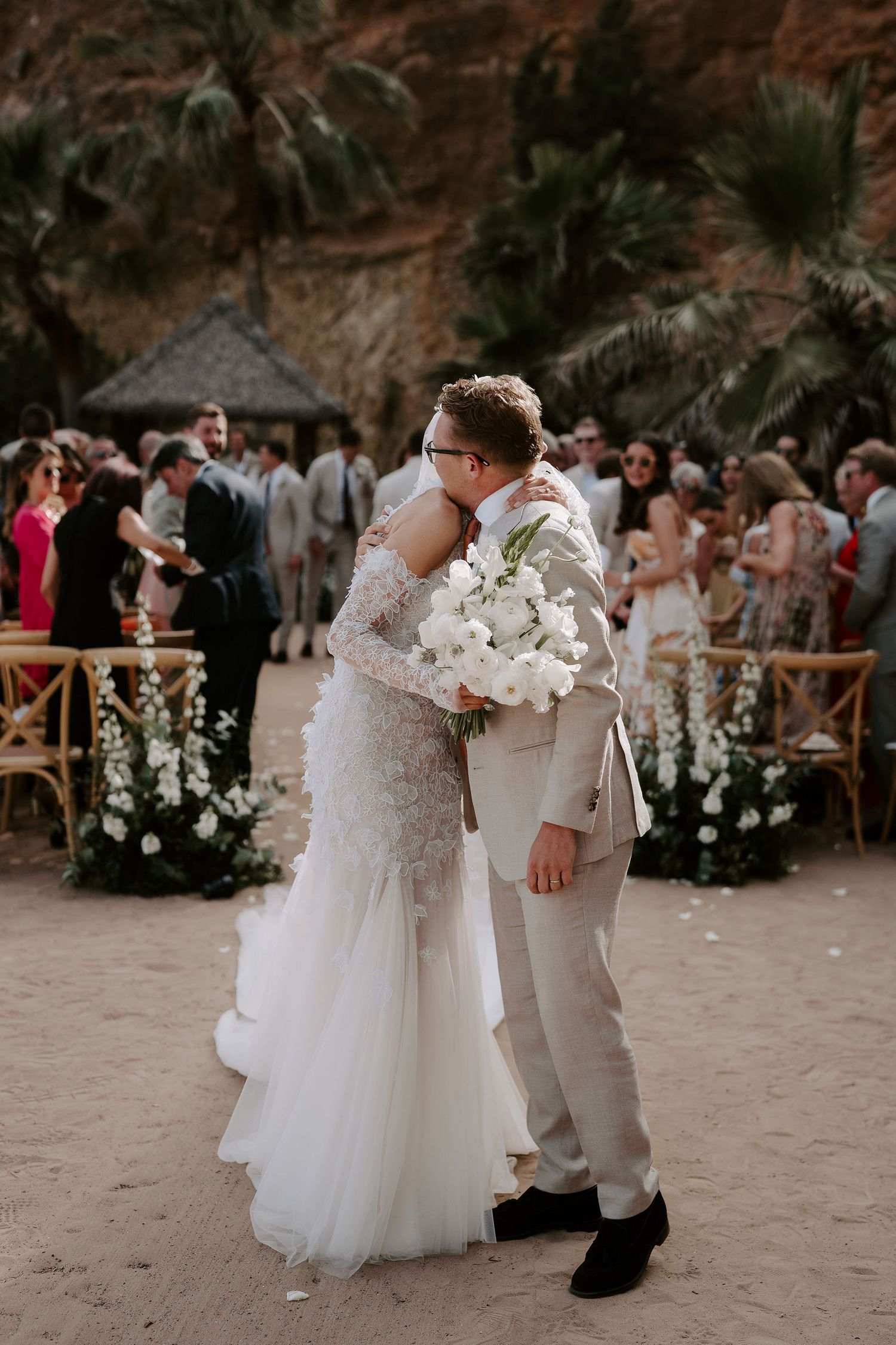 bride and groom embracing with wedding guests cheering at amante ibiza