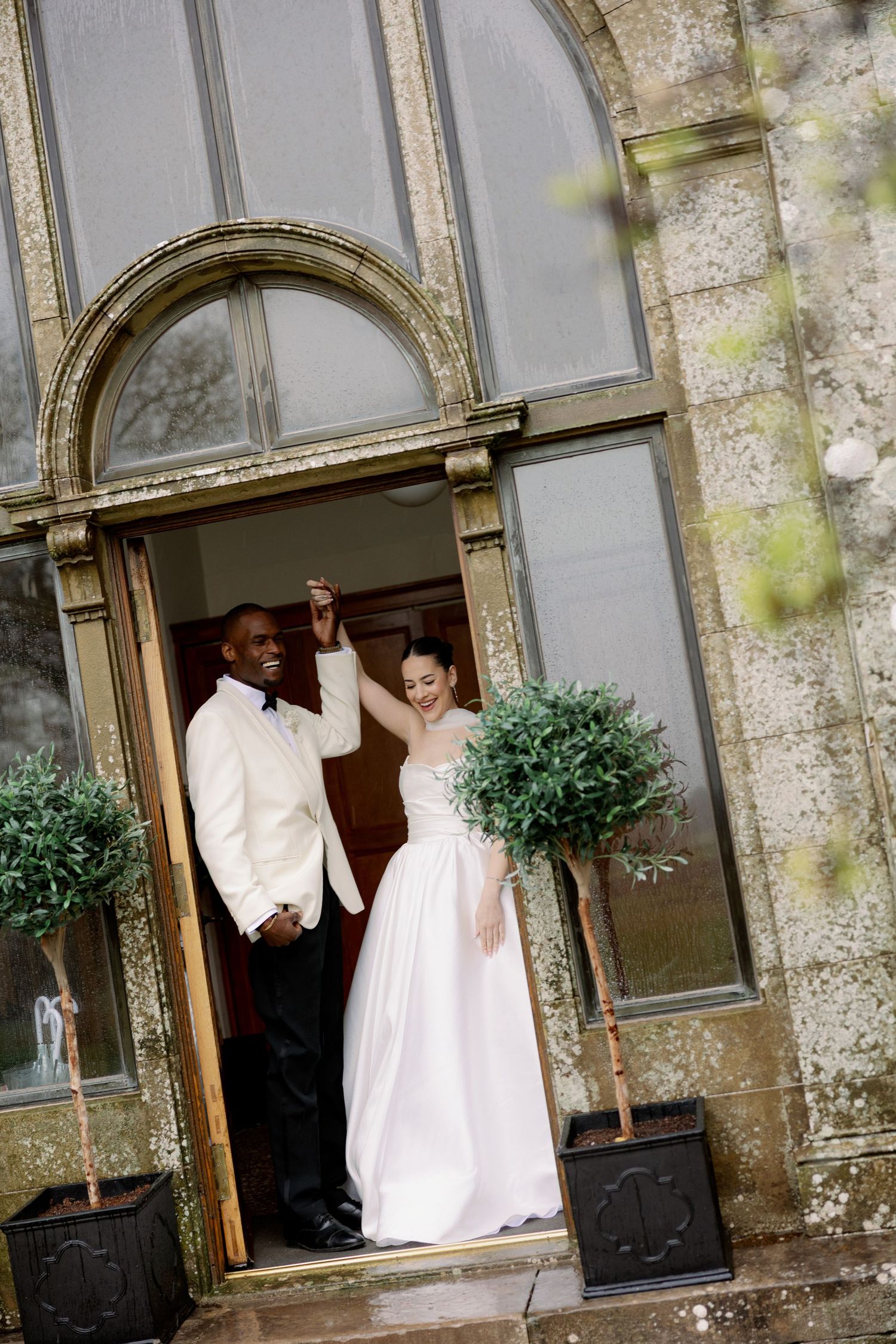 A couple in wedding attire poses gracefully on an elegant staircase during their special day.