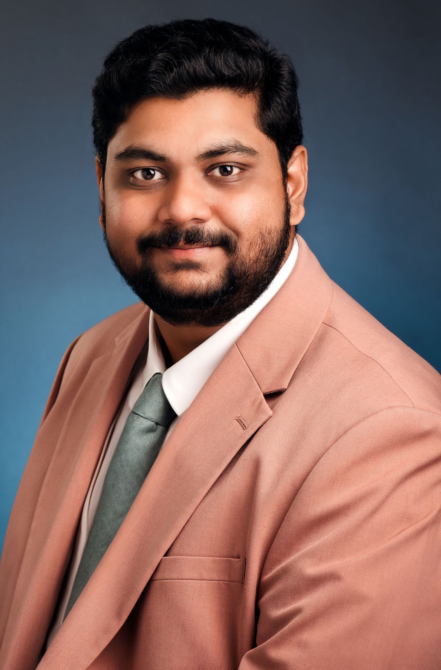Professional headshot series in salmon pink blazer against blue background.