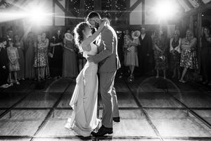 Black and white photo of newlyweds sharing a romantic first dance embrace on the wedding dance floor.