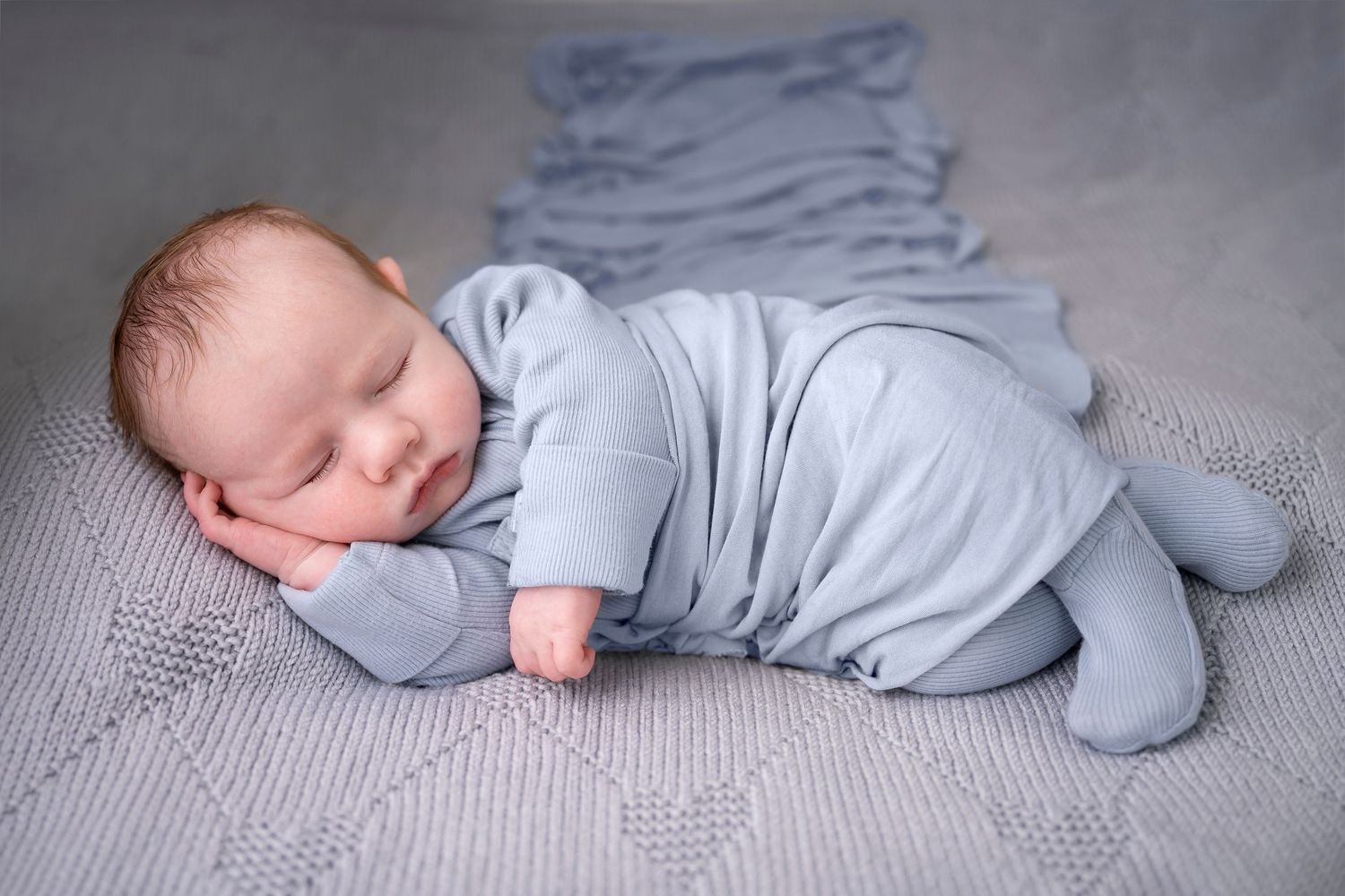 newborn photography studio ashford kent photo of a baby in blue laying on                        side timeless photography creating memories
