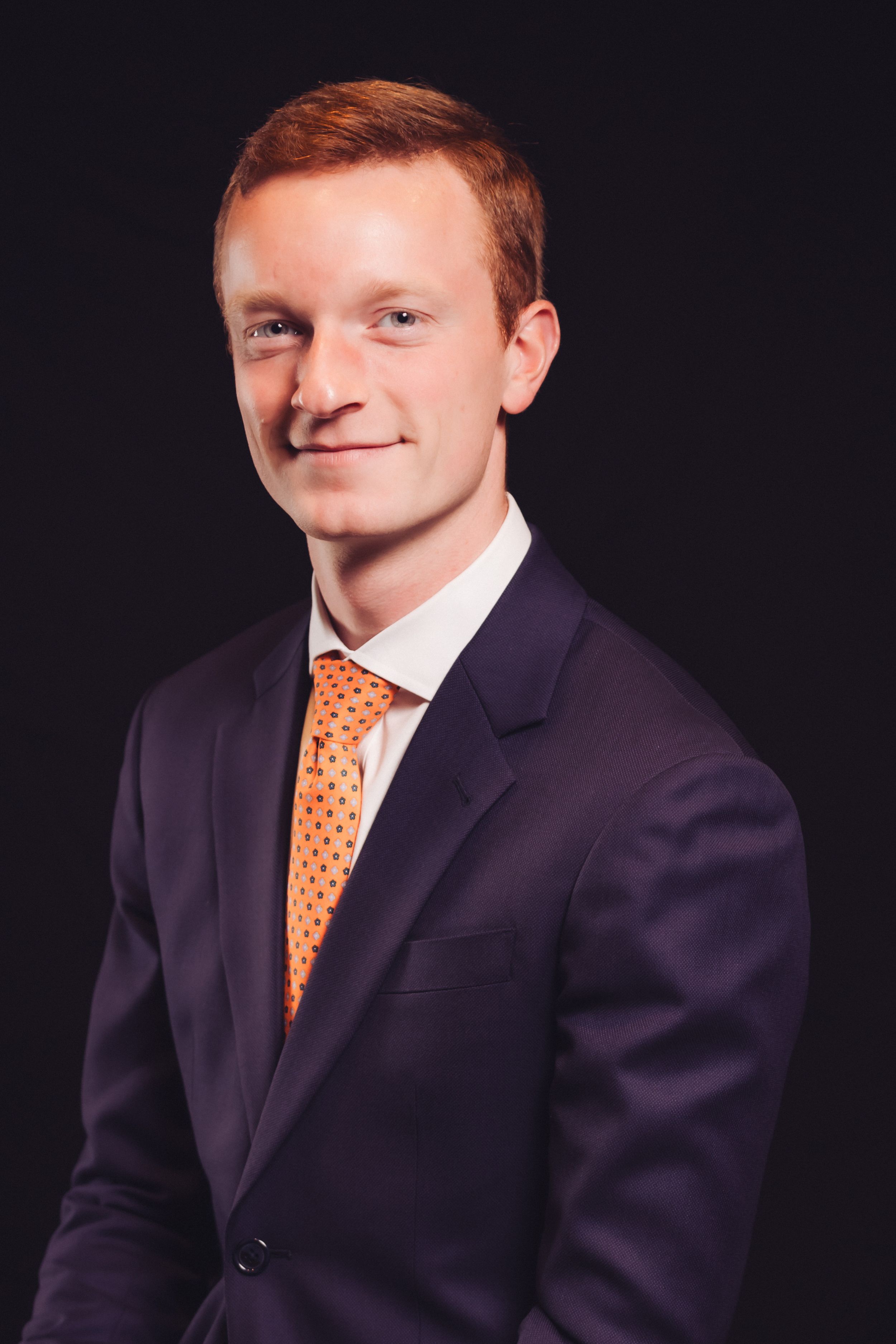Portrait corporate studio d'un dirigeant d'entreprise sur fond noir, éclairage professionnel élégant.