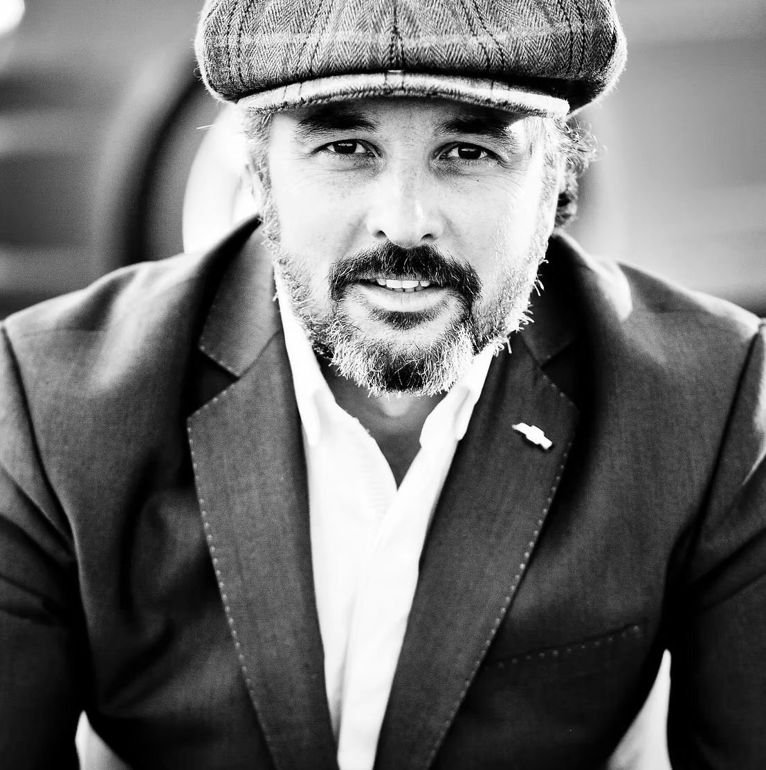 Portrait de caractère en noir et blanc d'Yvan Muller, pilote automobile de légende.