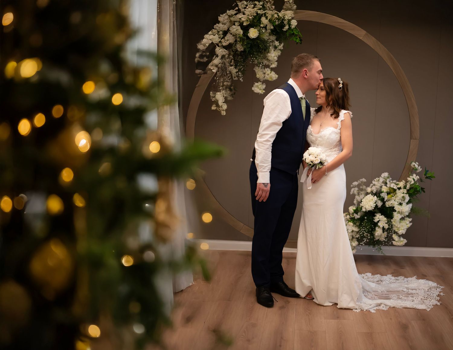 A tender moment between newlyweds sharing their first dance at a wedding reception, with the bride in a white gown.