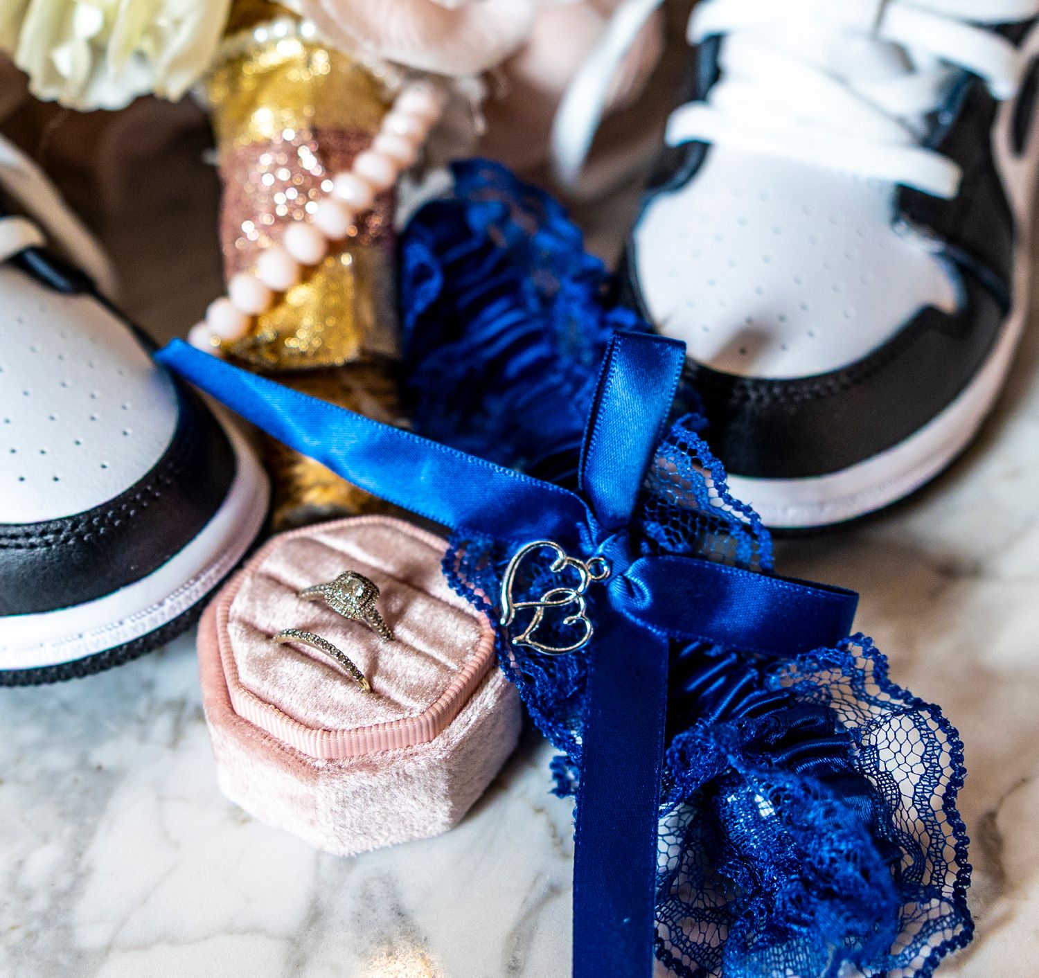 Elegant lingerie collection featuring delicate lace details in royal blue and soft pink tones laid out on white surface.