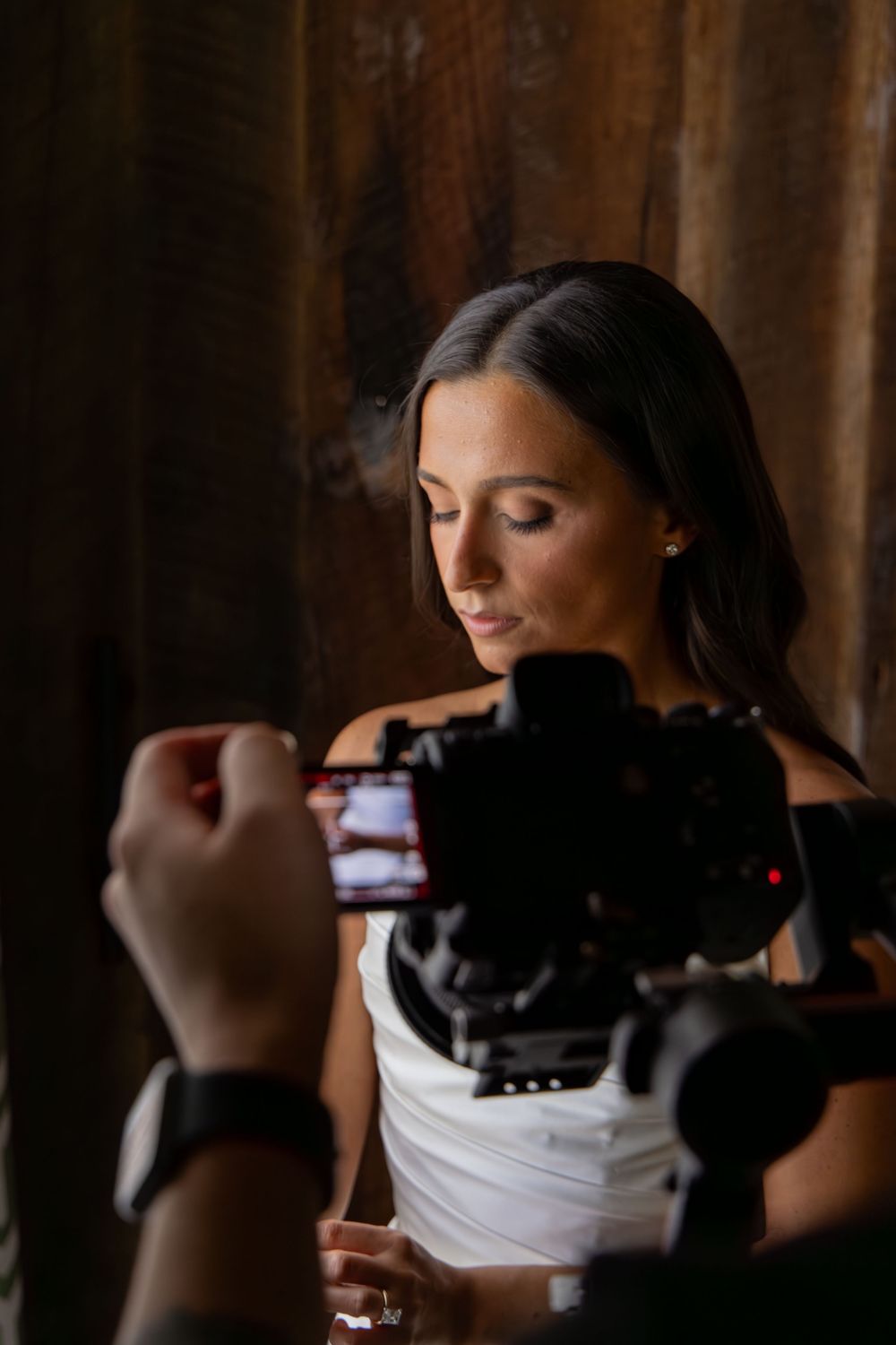 Behind-the-scenes shot of photographer capturing bridal portraits in a dark room.