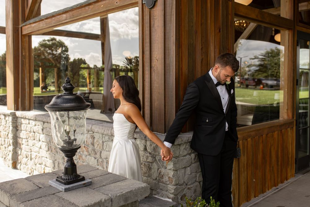 Rustic wooden and stone wedding venue exterior with elegant architectural details.