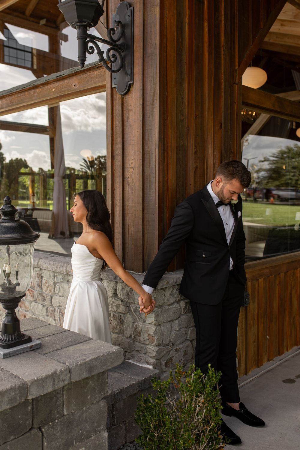 Wedding couple exchanging private moments on rustic stone porch before ceremony.