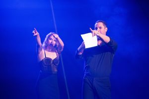 Concert stage illuminated by deep blue spotlights creating a moody atmosphere during a live performance.