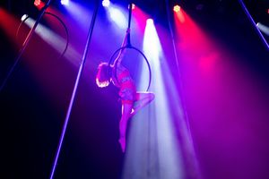 Dynamic red and blue stage lights casting dramatic beams through theatrical smoke.