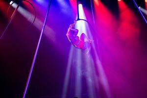 Theatrical lighting design featuring magenta and purple spotlights creating ethereal beams through haze.