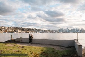 Scenic waterfront view of Seattle skyline on a cloudy day with residential buildings along the hillside.