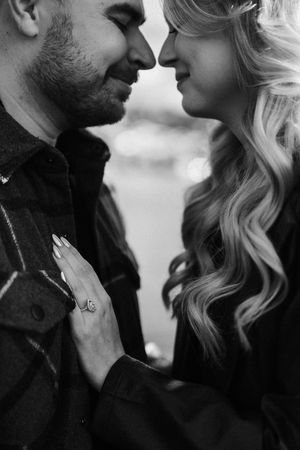 Black and white romantic couple photos showing tender intimate moments with the woman in light hair and man in dark clothing.