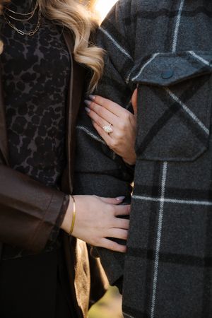 A person's hands shown against a dark plaid blanket or throw with white grid pattern.