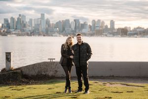 A series of romantic silhouettes against a city skyline backdrop during sunset at a waterfront location.