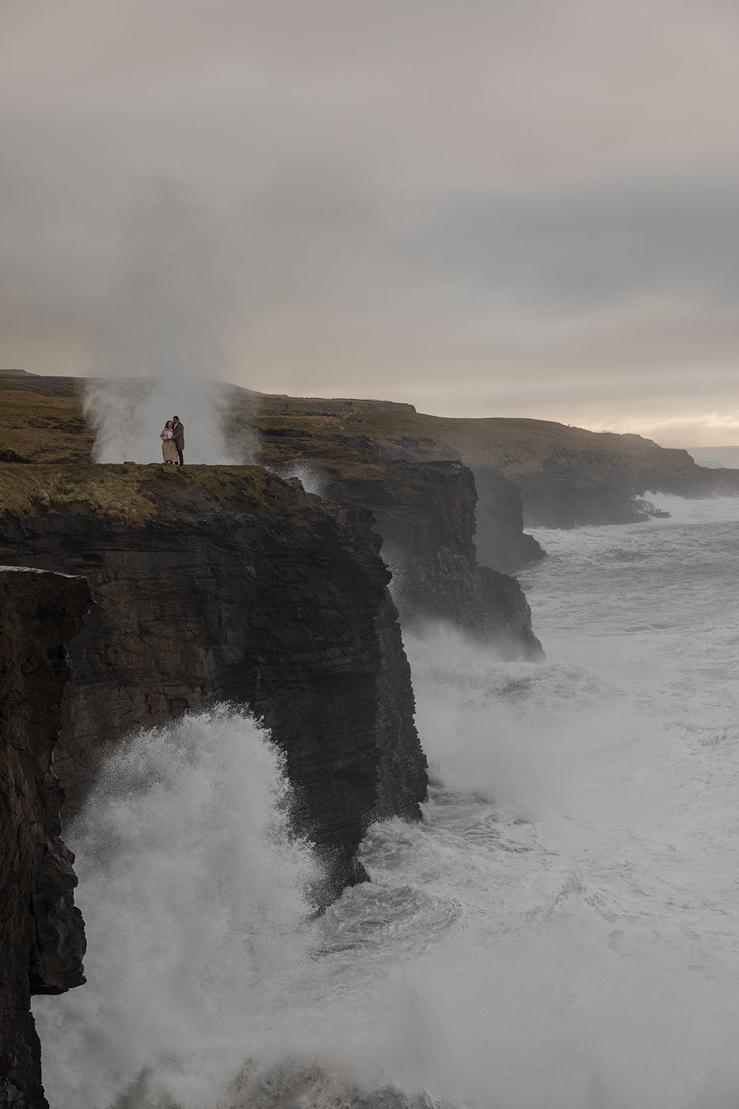 Dramatic sunset engagement portraits along Doolin Cliff Walk with high Atlantic waves