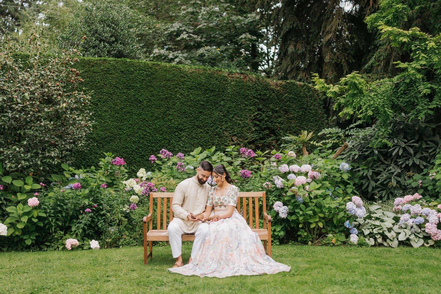 A romantic picnic scene in a lush garden setting with pink floral decorations and elegant table settings.