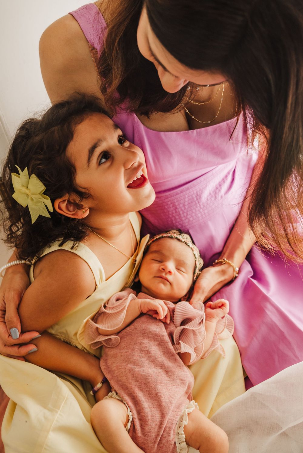 Mother and child share joyful moments together in warm pink and yellow tones across multiple candid photos.