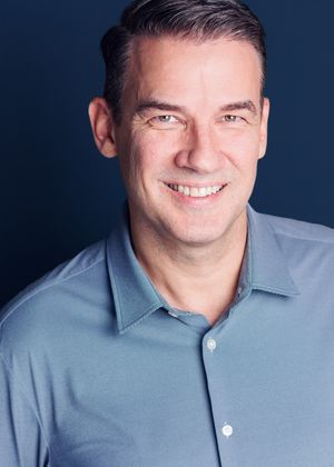 A series of headshots showing someone wearing a light blue button-down shirt against a dark background.