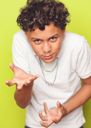 Young person in white t-shirt making various hand gestures against bright yellow background.