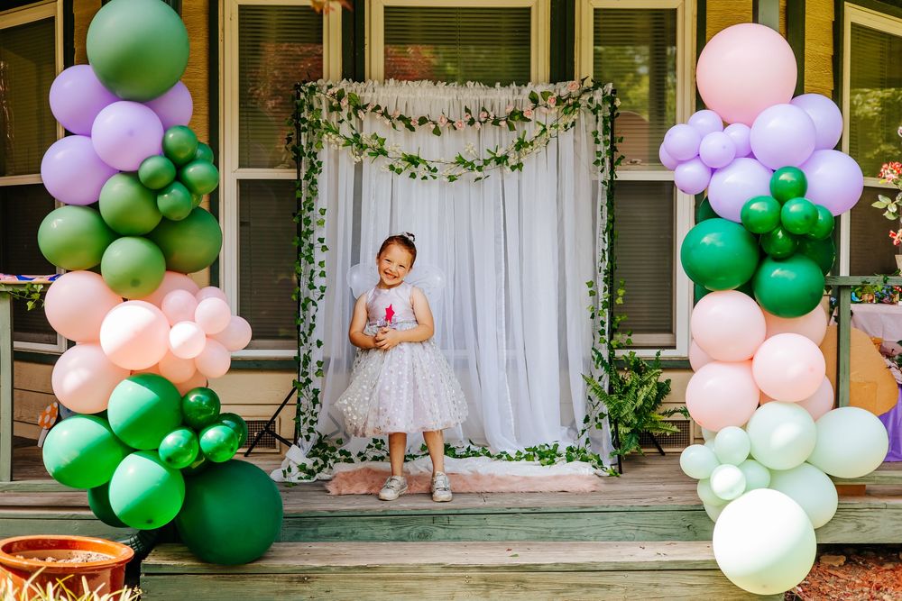 Festive balloon arch display in green, white and pink colors.