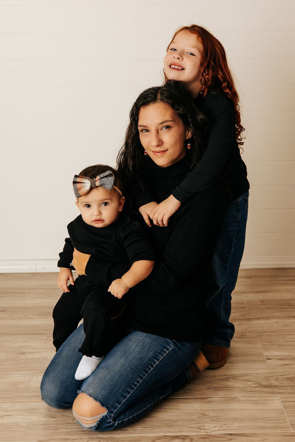 Casual family portraits in denim and black showing natural interactions.