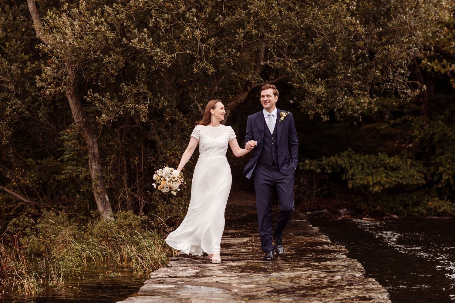 Newlywed couple poses for romantic wedding photos on rustic stone jetty at Storrs Hall