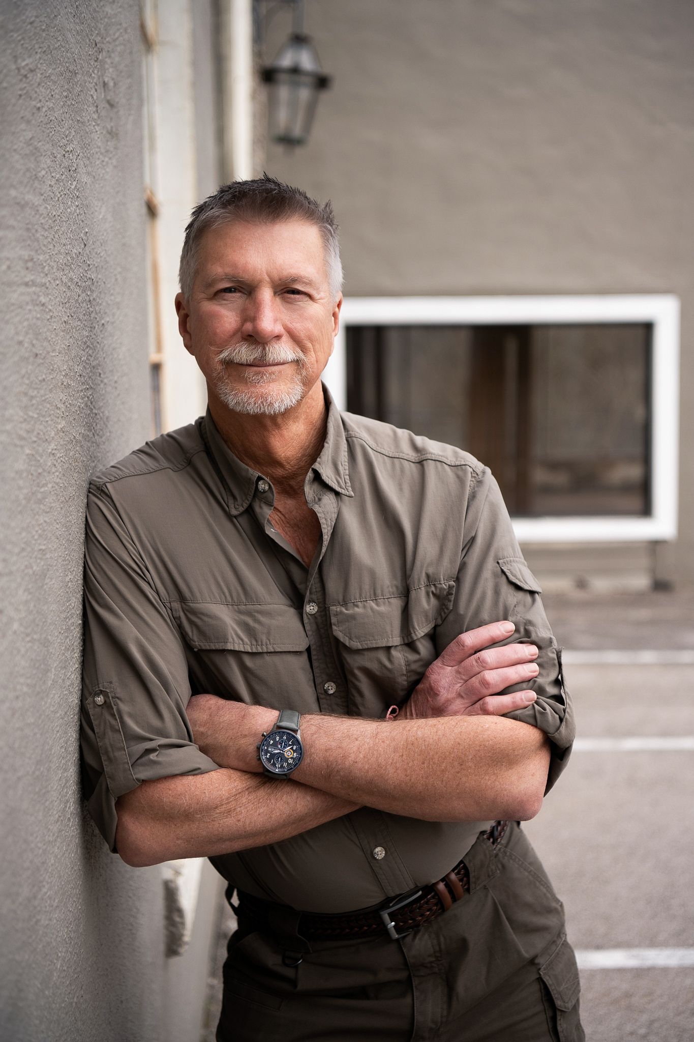 A series of four similar portrait photographs showing a person in a gray shirt against a concrete wall.