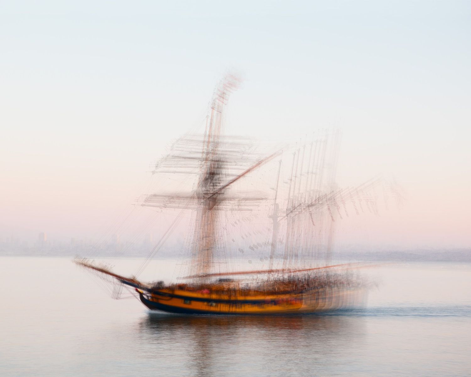 Artistic motion blur sequence of a sailing ship moving across calm waters at sunset.