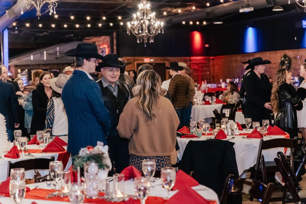 Western-themed party with guests in cowboy hats gathered around decorated tables.