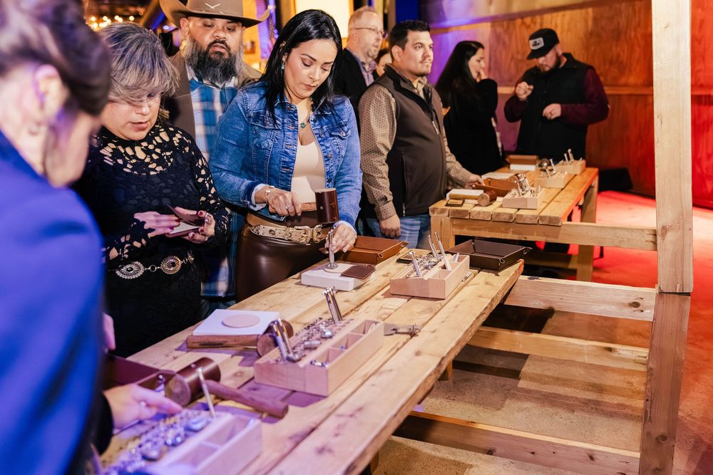 Event attendees interacting with wooden display items at a themed gathering.
