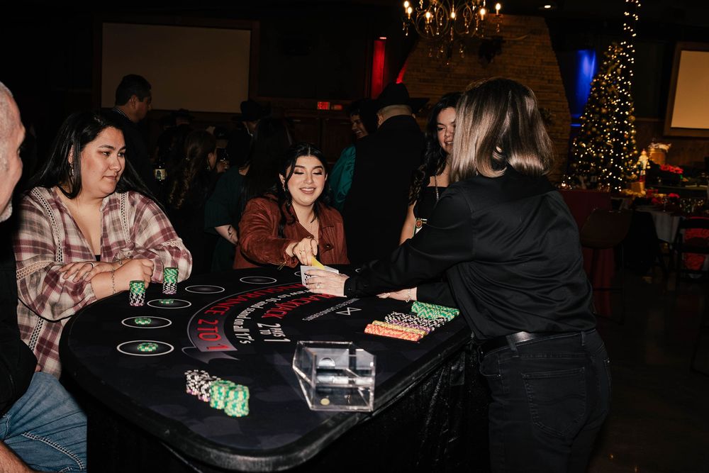 People gathered around tables in a darkened event space with ambient lighting.