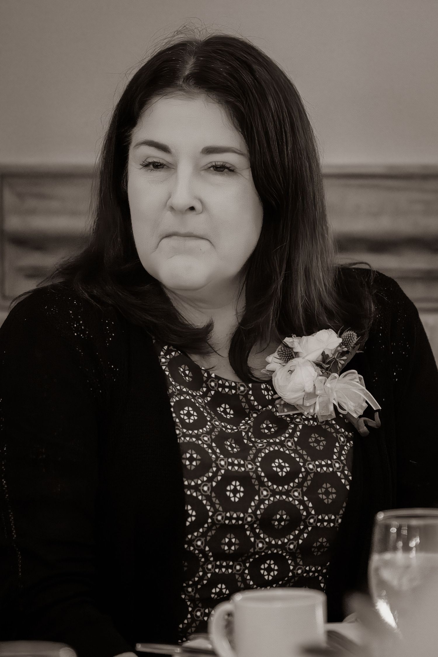 Frederick Maryland Wedding Photographer   A person in a black embellished top sits at a dining table in black and white photography.