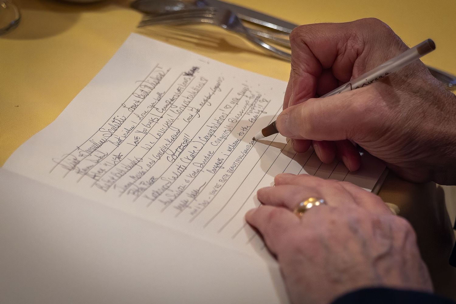Frederick Maryland Wedding Photographer   Close-up of hands signing documents on a table.