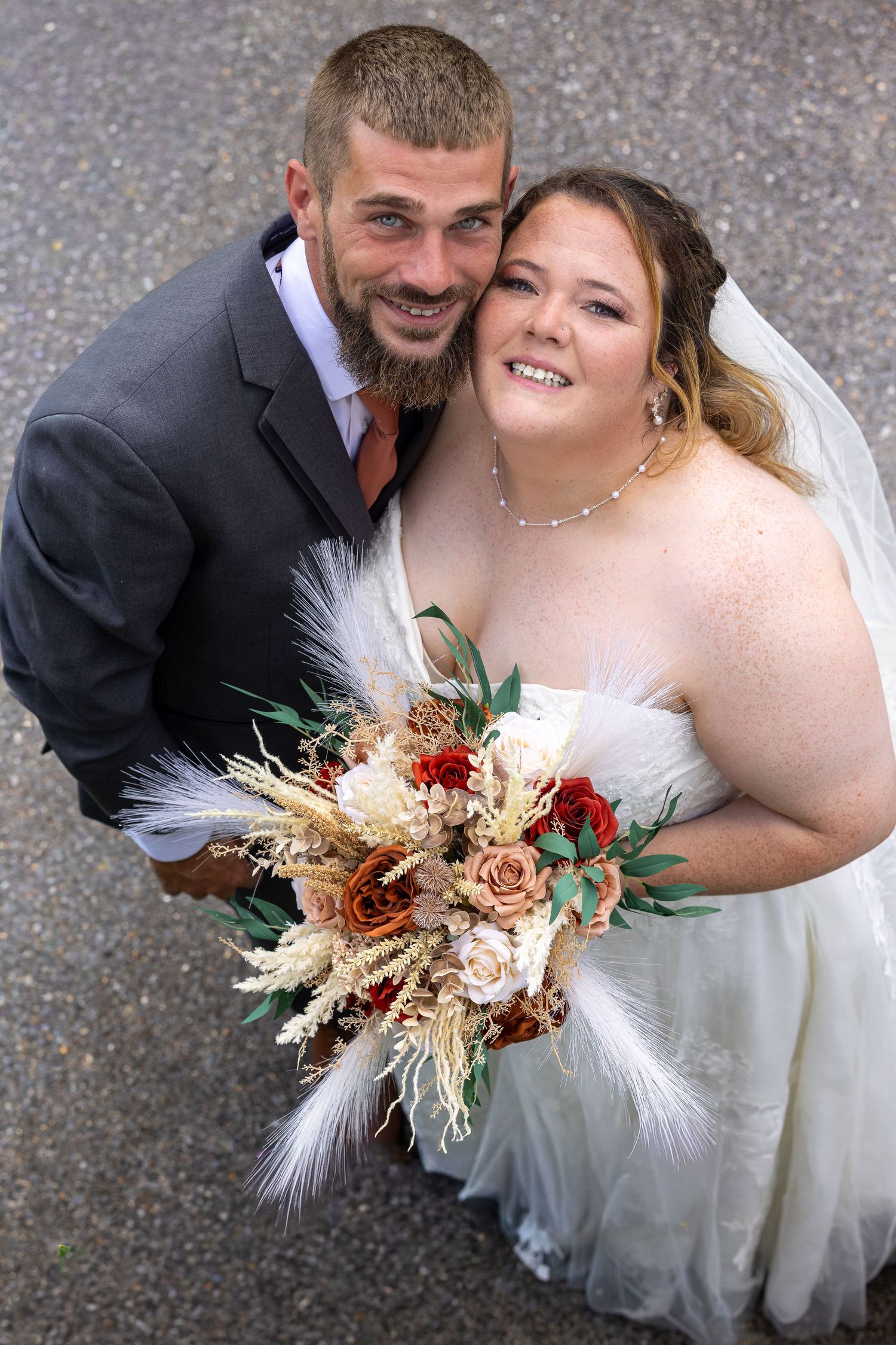 frederick maryland wedding photographer Wedding couple sharing an intimate moment with autumn-themed dried flower bouquet.