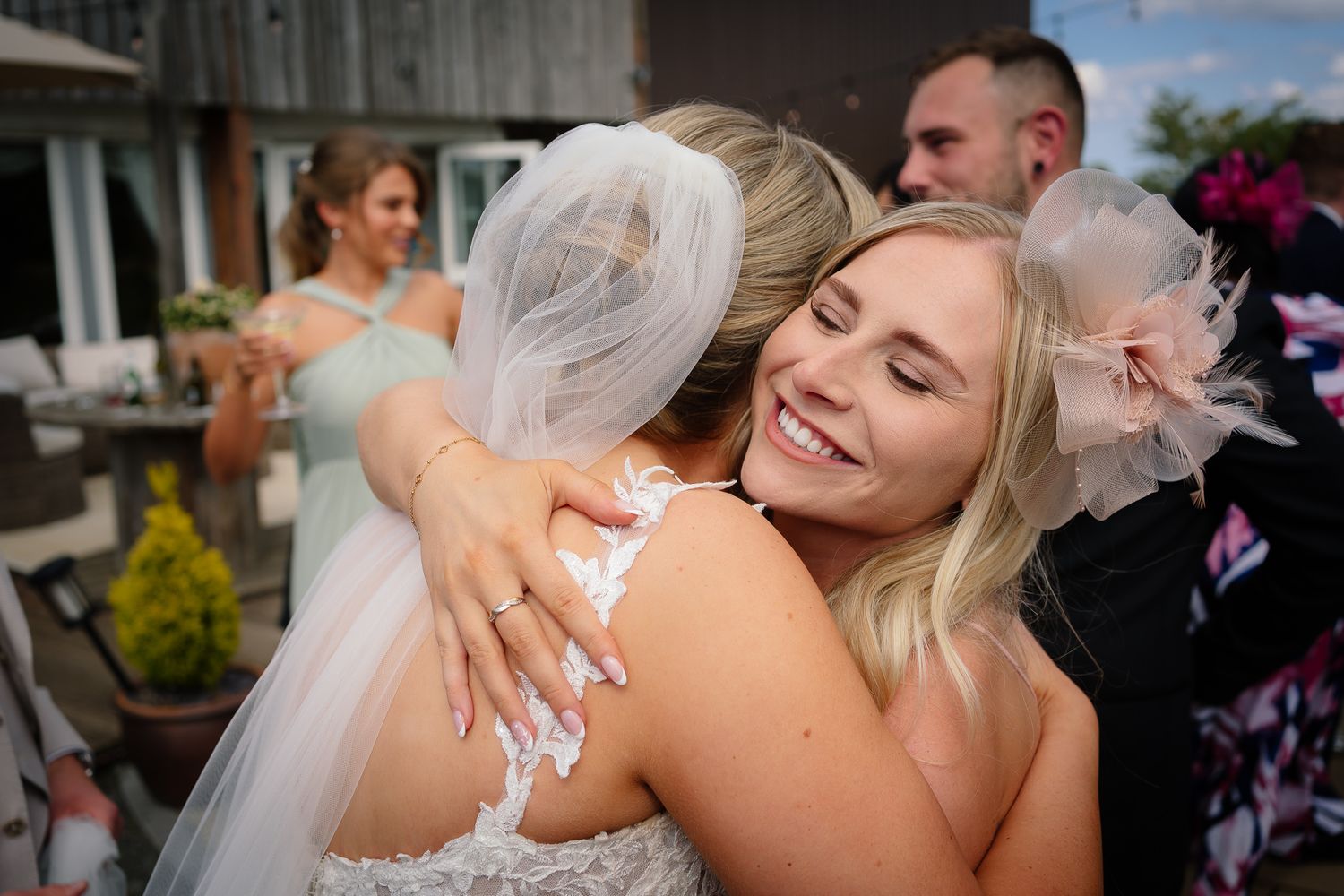 Emotional embraces shared between wedding guests and the bride during a joyful outdoor celebration.